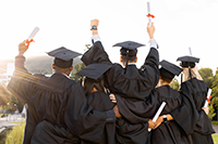 Photographie d'étudiants et d'étudiantes de dos, lors de leur remise de diplôme.